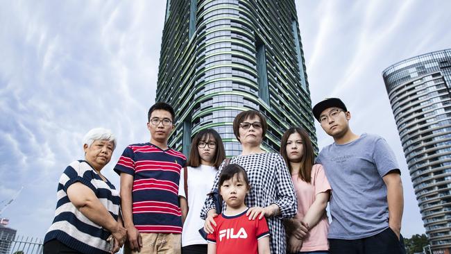 Residents, Vivian Lu (white t-shirt) with husband Eason (blue and red stripes) and her mother Missy (black and white stripes) and other angry residents outside the Opal Tower at Homebush in Sydney's west. Pic: John Feder/The Australian.