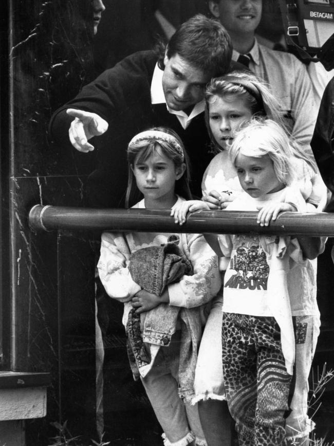 Footballer Greg Phillips points out his wife, Julie, to daughters Amy, Rachel and Erin from the balcony during SANFL grand final parade at the Renaissance Centre in 1990. Picture: Neon Martin