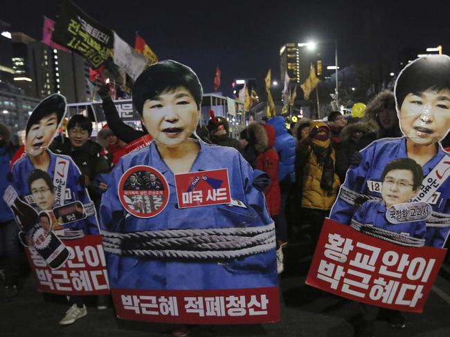 Protesters hold cutouts of impeached President Park Geun-hye. The signs read "Clean up Park Geun-hye's policy." Picture: AP.