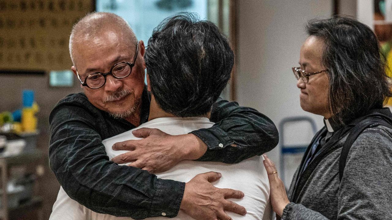 Two catholic priests hug and comfort a protester (C) in the campus of the Hong Kong Polytechnic University where dozens of pro-democracy protesters remain holed up, in the Hung Hom district of Hong Kong on November 24, 2019. Picture: Nicolas Asfouri / AFP