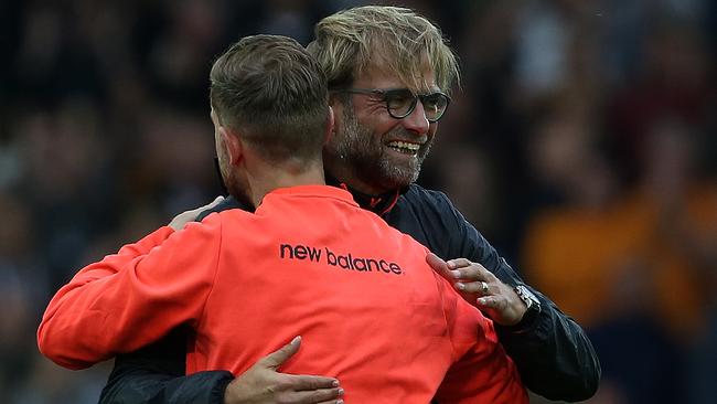 Liverpool's German manager Jurgen Klopp (R) hugs Liverpool's English midfielder Jordan Henderson.