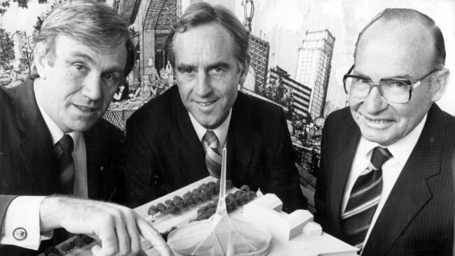 1984. Planning and Environment minister Evan Walker, Premier John Cain and Frank Woodcock, Jennings' General Manager of Investment and Development, with a model of the Yarra River project. Neg: 841103/199