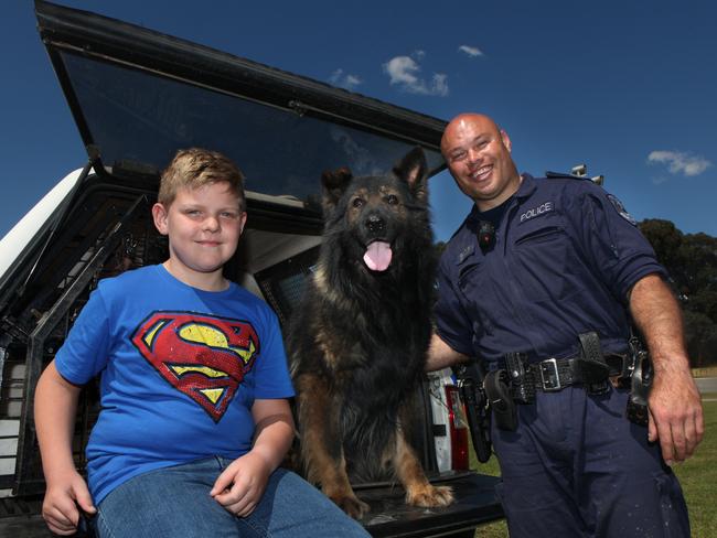 Zachary Vigors, 9, from Casula with Senior Constable Leo Clarke and his Police dog Demon. Photos: Robert Pozo