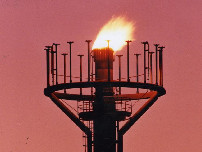 Santos Ltd's oil and gas operations at Moomba, SA, 20 May 1994.  The burn-off tower silhouetted against an Outback sunrise.