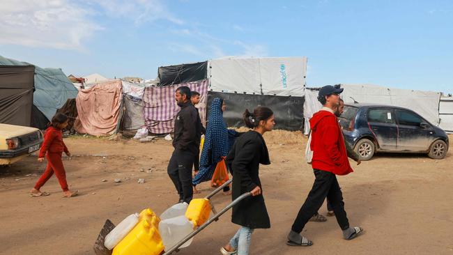 A Palestinian girl carries containers filled with water in Rafah as people struggle to find food. Picture: AFP