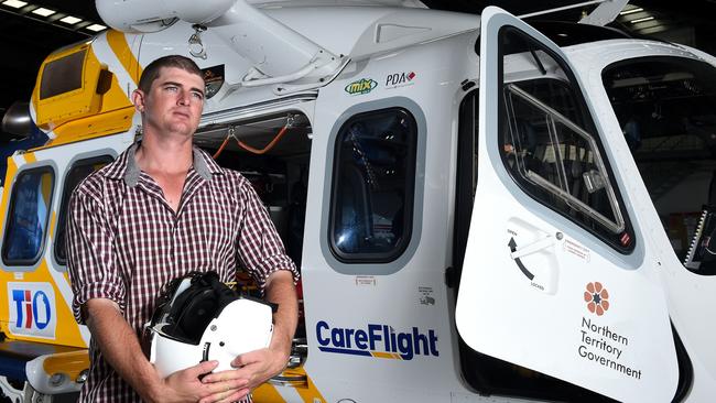 Pilot Matt Gane at the CareFlight hangar in Darwin with a replica of the helmet he wore the day his helicopter crashed near Borroloola. PICTURE: Justin Kennedy