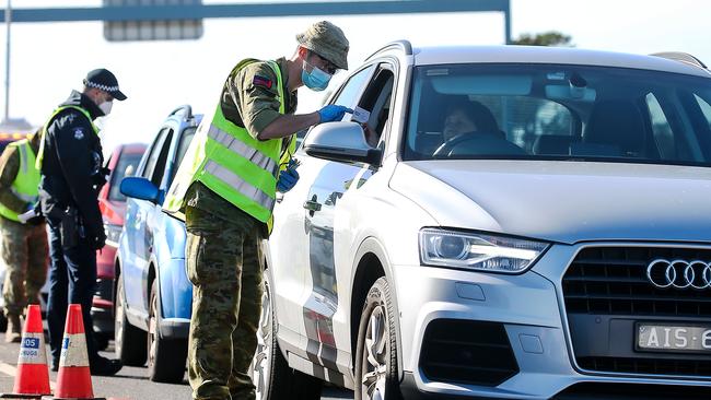 Victoria Police and Australian Defence Force personnel inspect cars at a vehicle checkpoint on the Princes Highway at Little River near Geelong. Picture: NCA NewsWire / Ian Currie
