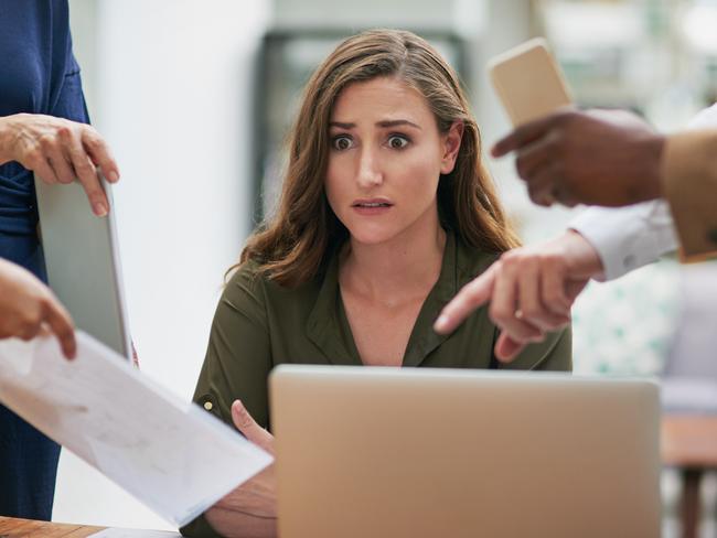 CAREERS: Shot of a young businesswoman looking anxious in a demanding office environment.