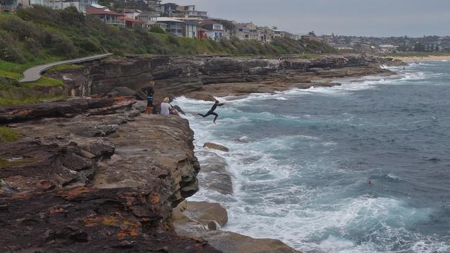 Young teenagers take a death-defying leap from the rocks at Curl Curl. Picture: Edita Pahor.