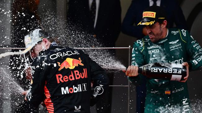 Winner Max Verstappen (centre) is sprayed with champagne by third-placed Aston Martin driver Fernando Alonso. Photo by Jeff PACHOUD / AFP