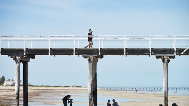 People enjoying the beach early in the morning at Largs Bay jetty. Picture: AAP Image/ Brenton Edwards)