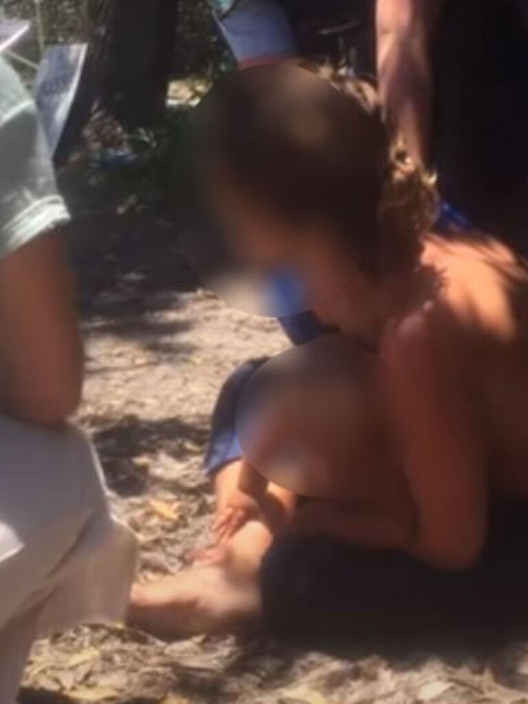 The topless mother cried as authorities took her child.