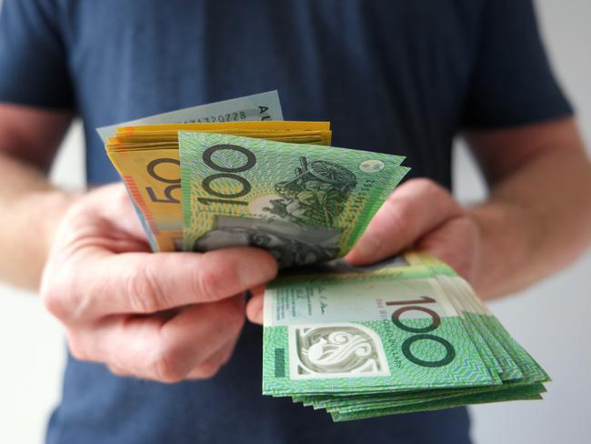 A man counting Australian dollar bills. A picture that describes buying, paying, handing out money, or showing money.