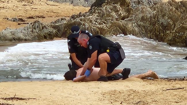 Police took the man into custody on the beach after he entered the water and started swimming towards Double Island.