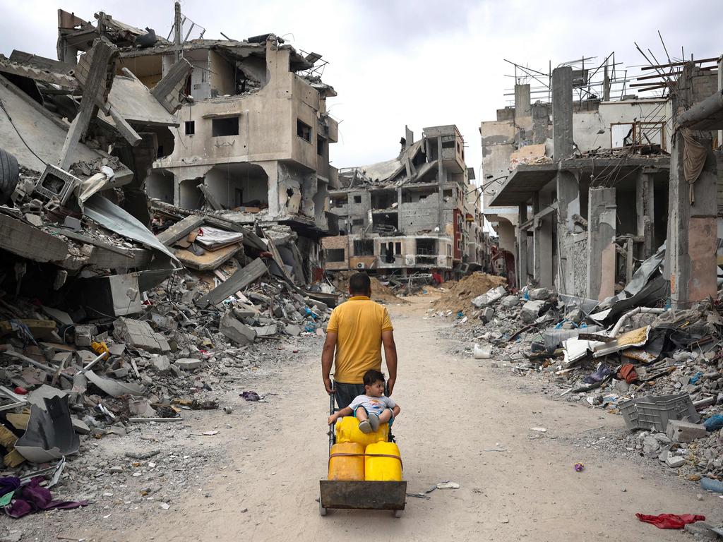 A Palestinian man pulls a cart on a road lined with destroyed buildings in Khan Yunis in the southern Gaza Strip. Picture: AFP