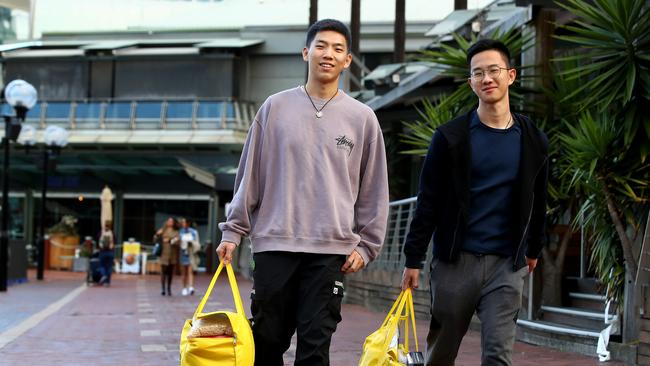 Chinese students Kun Liu and Yongxian Li collect charity food hampers for international students struggling to make ends meet during the pandemic in Sydney. Picture: Toby Zerna