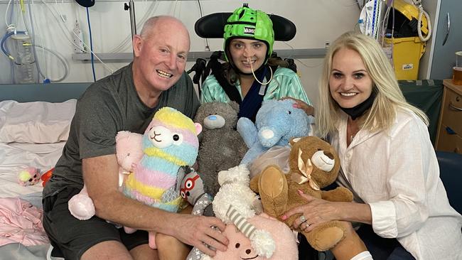 Alexa Leary (middle) with parents Russell (left) and Belinda (right) in hospital after the bike crash.