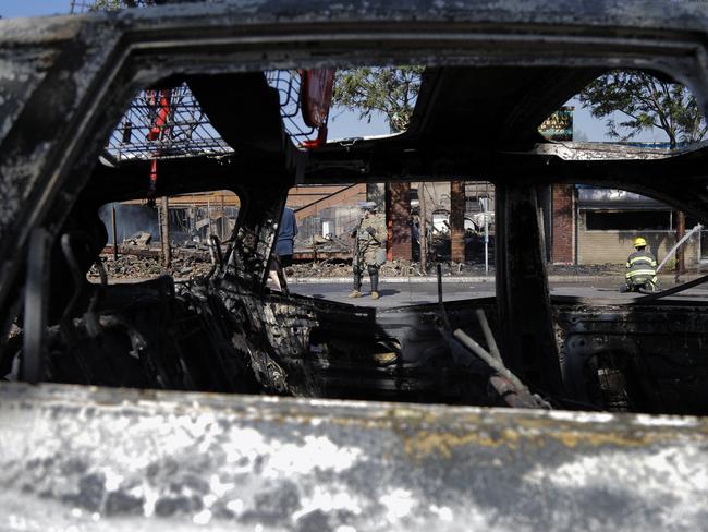 Members of the National Guard secure the area as firefighters continue to douse flames in Minneapolis following protests over the death of George Floyd. Picture: AP Photo/Julio Cortez