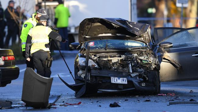 Investigators yesterday, inspect the car that ran into pedestrians at the Collingwood brawl. Picture: AAP