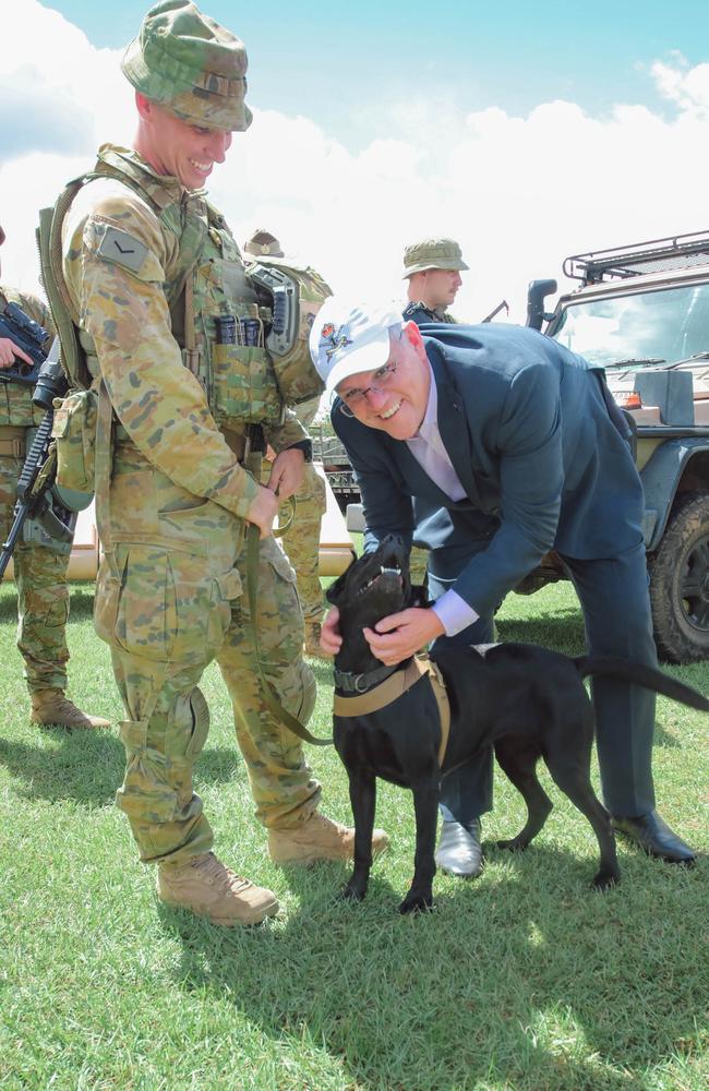 Prime Minister Scott Morrison with mine detector dog Lena as he visits Australian and American personnel at Darwin's Robertson Barracks. Picture Glenn Campbell