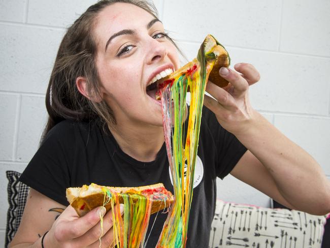 8 Seeds employee Natasha Condo enjoys the new rainbow toastie. Picture: Eugene Hyland