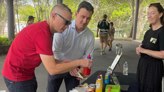 Bonney LNP MP Sam O'Connor buying a "democracy" sausage at the Labrador State School polling booth. Volunteer and community worker Jenna Schroeder is serving him. He moved to Pacific Pines to help in Gaven after. Picture: Paul Weston.