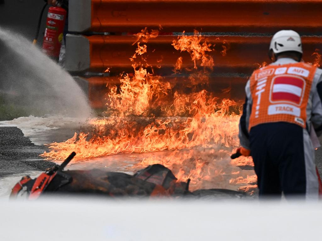 Track marshals try to extinguish the fire.