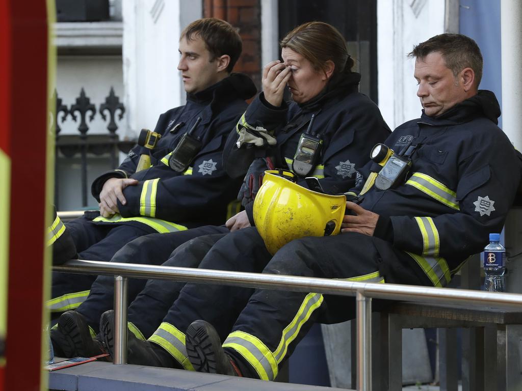 Firefighters wait to start their shift during the massive operation to fight the fire in the 27-storey high-rise apartment building. Picture: AP/Matt Dunham