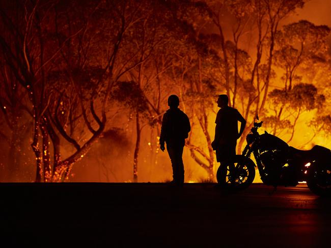 LAKE TABOURIE, AUSTRALIA - JANUARY 04: Residents look on as flames burn through bush on January 04, 2020 in Lake Tabourie, Australia. A state of emergency has been declared across NSW with dangerous fire conditions forecast for Saturday, as more than 140 bushfires continue to burn. There have been eight confirmed deaths in NSW since Monday 30 December. 1365 homes have been lost, while 3.6 million hectares have been burnt this fire season. (Photo by Brett Hemmings/Getty Images)