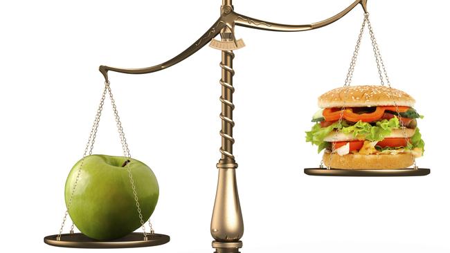 Apple and hamburger on scales. Food. Health. Junk food. Conceptual. Generic image.