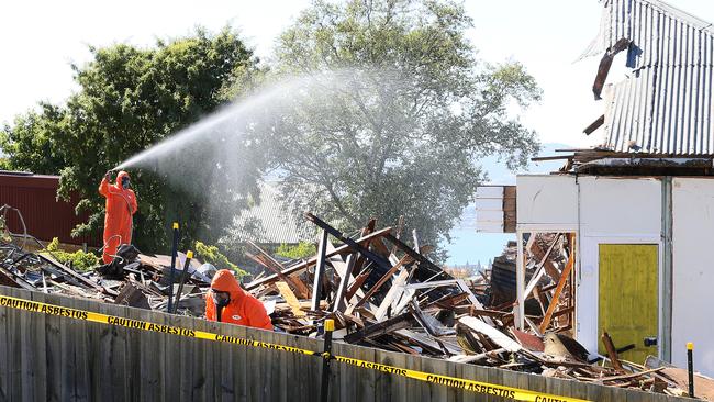 Workers hose down the debris after the demolition work.