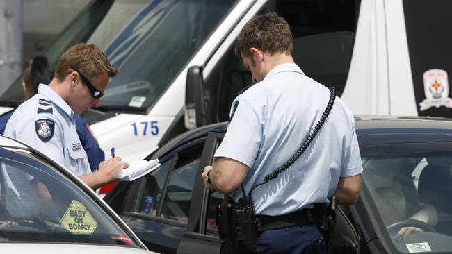 Police talk to a member of the public after a child is locked in a car. 