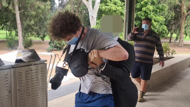 A protester is tackled after trying to gatecrash Premier Steven Marshall's daily Covid press conference. Picture: Andrew Hough