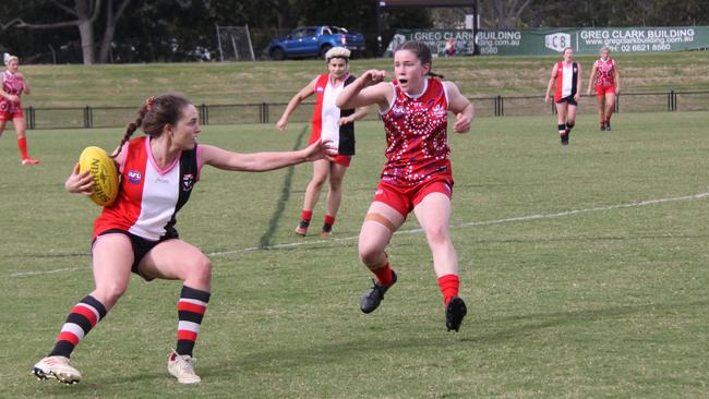 FEROCIOUS FOOTY: At Oakes Oval, Sawtell Saints captain Vienna Schoeffel, tries to avoid determined Swans player Holly Wall, during a hard fought game in the Sir Doug Nicholls Round on May 29, 2021. Photo: Alison Paterson