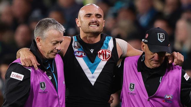 ADELAIDE, AUSTRALIA - APRIL 26: Sam Powell-Pepper of the Power in the hands of medical staff after hurting his knee during the 2024 AFL Round 07 match between the Port Adelaide Power and the St Kilda Saints at Adelaide Oval on April 26, 2024 in Adelaide, Australia. (Photo by Sarah Reed/AFL Photos via Getty Images)