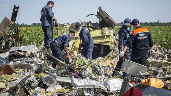 RASSIPNOYE, UKRAINE - JULY 20:  Ukrainian rescue servicemen inspect part of the wreckage of Malaysia Airlines flight MH17 on July 20, 2014 in Rassipnoye, Ukraine. Malaysia Airlines flight MH17 was travelling from Amsterdam to Kuala Lumpur when it crashed killing all 298 on board including 80 children. The aircraft was allegedly shot down by a missile and investigations continue over the perpetrators of the attack.  (Photo by Rob Stothard/Getty Images)