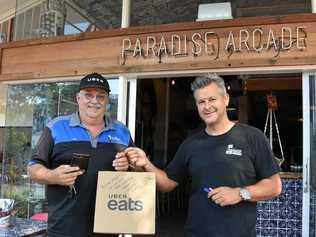 FAST FOOD: Uber Eats delivery driver Rick Bolsterli collected Paradise Arcade's first Uber Eats order from owner Colin Benge. Picture: Caitlin Zerafa