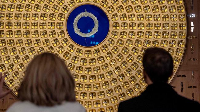 Brigitte and Emmanuel Macron survey the Crown of Thorns, designed by French artist Sylvain Dubuisson, during their visit to the world-heritage landmark. Picture: AFP