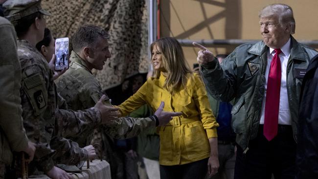 ‘It’s not fair when the burden is all on us’: Melania and Donald Trump greet the troops at Al-Asad Air Base, Iraq, yesterday. Picture: AP