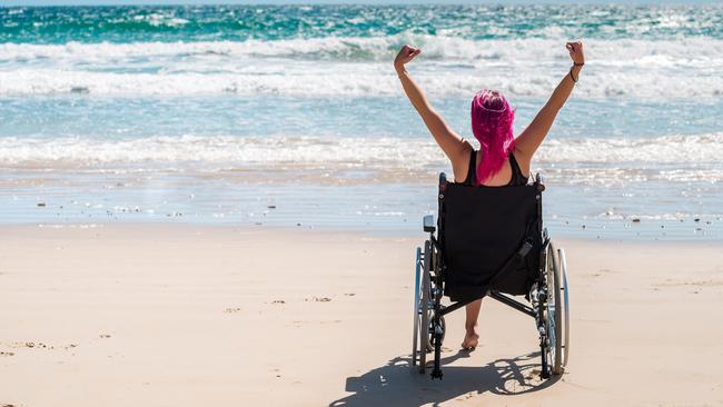 Disabled woman in the wheelchair at the beach