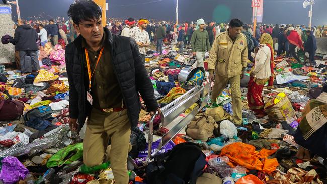 Police officials carry a stretcher among piles of personal belongings after a stampede at the the Kumbh Mela on Wednesday in Allahabad, India. Picture: Getty Images