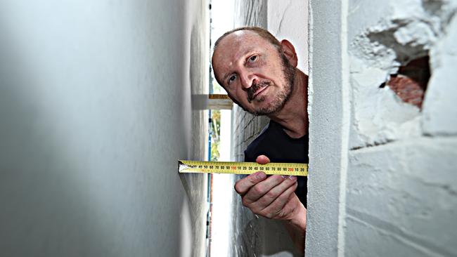 Unit owner Stephanus Potgieter measures the narrow distance between his home and a neighbouring apartment block. Pic Annette Dew