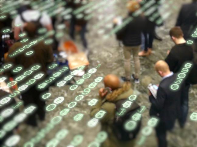 People waiting in a crowd and using their phones. Istock