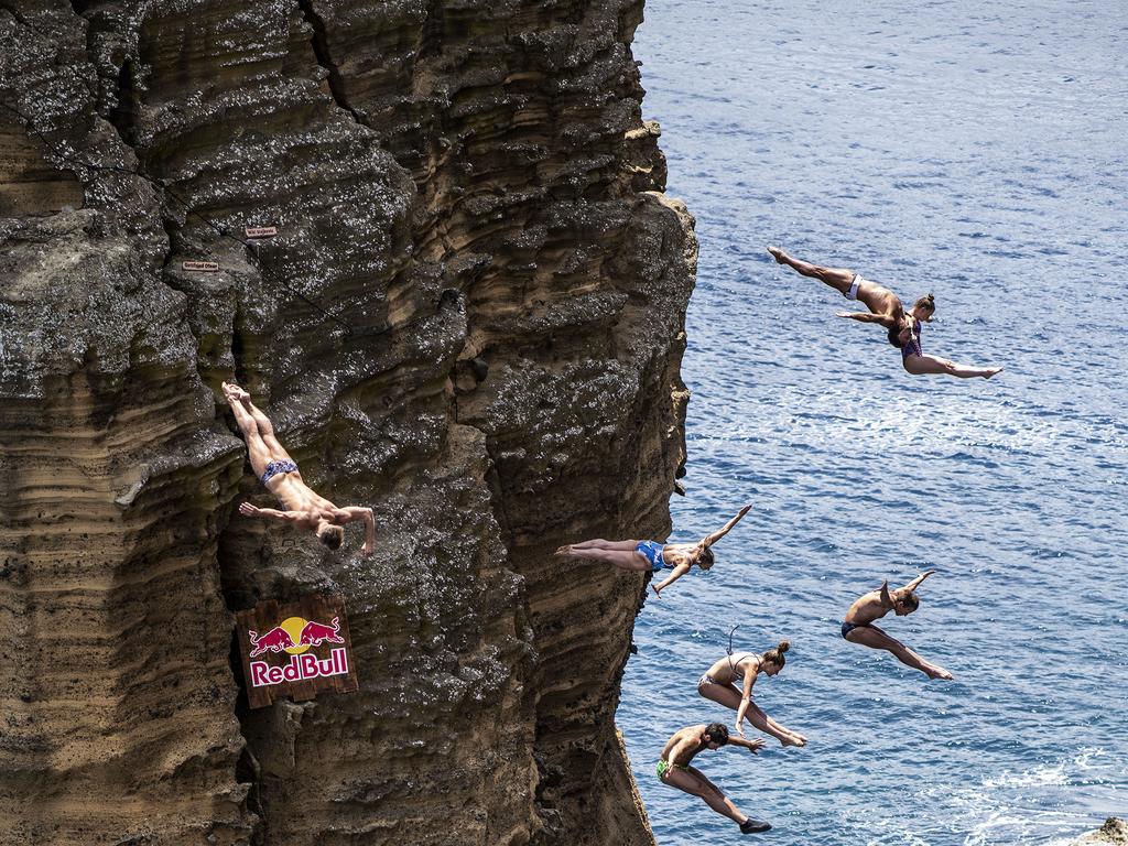 Nikita Fedotov of Russia, Lysanne Richard of Canada, Slavik Kolesnikov of the Ukraine, Jessica Macaulay of the UK, Todor Spasov of Bulgaria, Robin Georges of France and Ellie Townsend Smart of the USA dive from the rock monolith at Islet Vila Franca do Campo after the first training session of the third stop of the Red Bull Cliff Diving World Series on July 12, 2018 at Sao Miguel, Azores, Portugal. (Photo by Dean Treml/Red Bull via Getty Images)