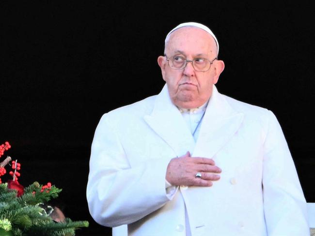 TOPSHOT - Pope Francis stands at the main balcony of St. Peter's basilica to deliver the Urbi et Orbi message and blessing to the city and the world as part of Christmas celebrations, at St Peter's square in the Vatican on December 25, 2024. (Photo by Alberto PIZZOLI / AFP)