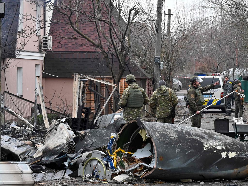 Ukrainian servicemen work by the wreckage of an unidentified aircraft which crashed into a private house in a residential area in Kyiv. Picture: AFP