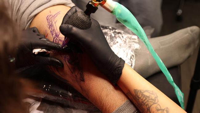 A tattoo artist from Devonport will be spending two years behind bars. (Photo by ATTA KENARE / AFP)