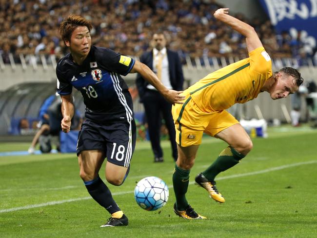 Japan's Takuma Asano, left, takes the ball away from Australia's Brad Smith