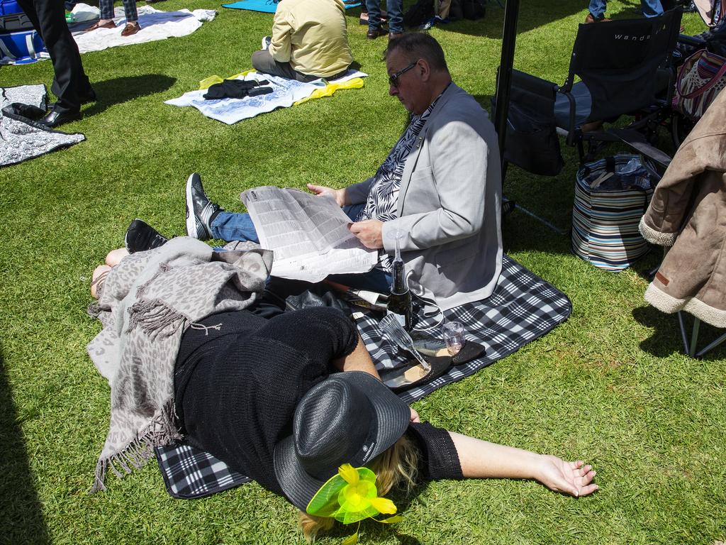 A woman takes a breather as a man studies the race form. Picture: Jenny Evans/Getty Images