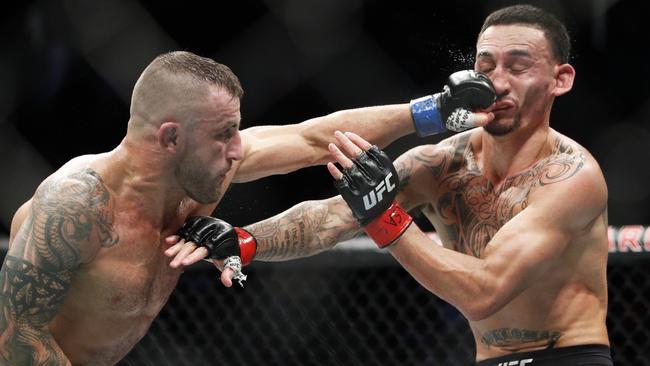 Alexander Volkanovski hits Max Holloway in a mixed martial arts featherweight championship bout at UFC 245, Saturday, Dec. 14, 2019, in Las Vegas. (AP Photo/John Locher)